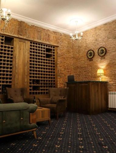 a living room with a brick wall and furniture at Belona Hotel in Kutaisi