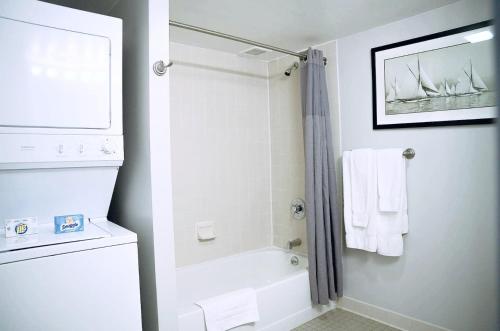 a white bathroom with a shower and a toilet at Cozy Apartment Downtown in Stamford