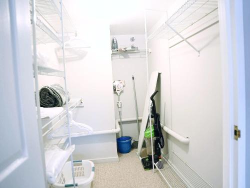 a room with white walls and a closet with shelves at Cozy Apartment Downtown in Stamford