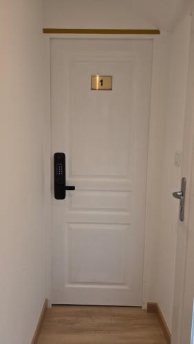 une porte blanche avec un téléphone en haut dans l'établissement La Perle Rare, à Massy