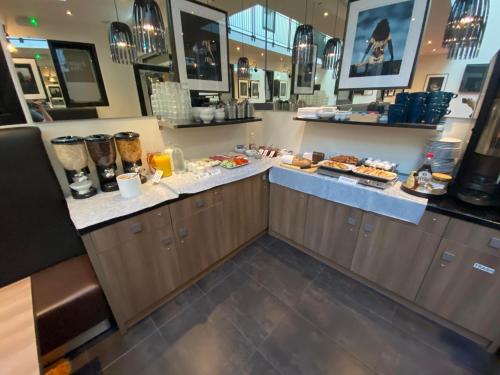 a restaurant with a counter with food on it at Hotel Jomfru Ane in Aalborg