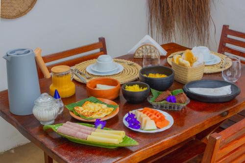 a wooden table with plates of food on it at Araxá Milagres in São Miguel dos Milagres