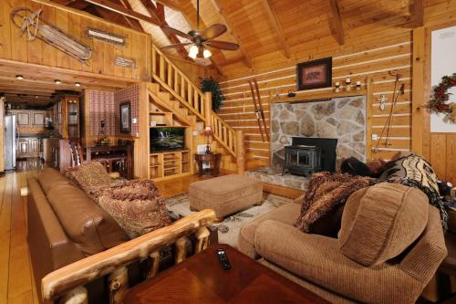 a living room with couches and a fireplace in a log cabin at Park Paradise #254 in Sevierville