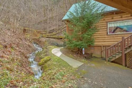 a path leading to a log cabin with a creek at Park Paradise #254 in Sevierville