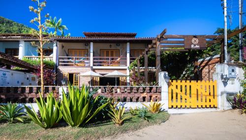 a house with a yellow gate in front of it at Pousada Rubi in Abraão