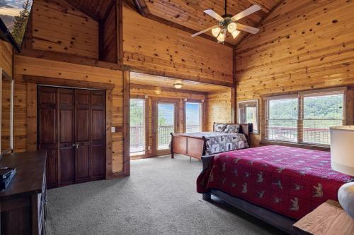 een slaapkamer in een blokhut met een bed en een plafondventilator bij Pinnacle Pool View Lodge #625 in Gatlinburg