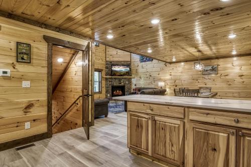 a kitchen with wooden walls and a fireplace at Pooling Around #200 in Gatlinburg