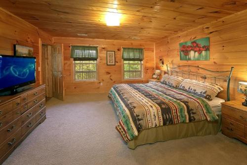 a bedroom with a bed and a flat screen tv at Private Paradise #2810 in Pigeon Forge