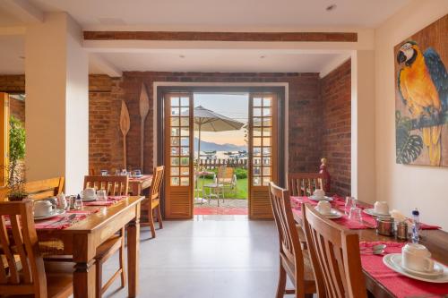 a dining room with tables and chairs and a patio at Pousada Rubi in Abraão