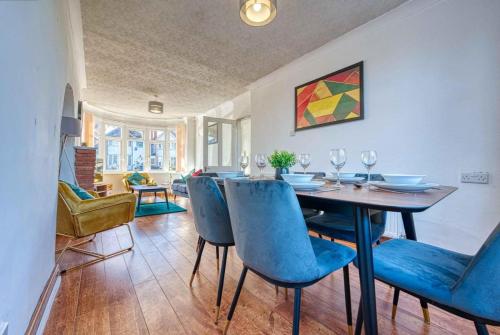 a dining room with a table and blue chairs at Spacious 3BR Home with Driveway Near NEC & Airport in Birmingham
