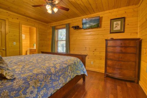 Un dormitorio con una cama y un ventilador de techo. en Skinny Dippin' #261, en Pigeon Forge