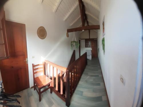 a hallway with a wooden staircase and a chair at Sunbeachparadise in Port-Louis