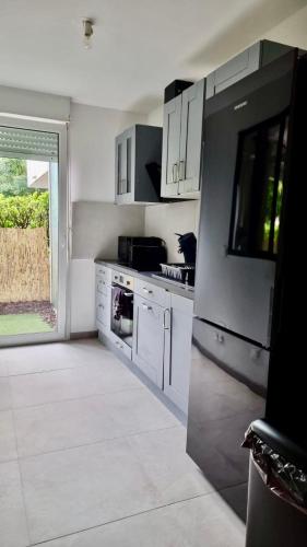 une cuisine avec des appareils blancs et une grande fenêtre dans l'établissement Cosy family spa Strasbourg center, à Strasbourg