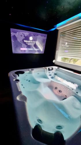 a bath tub with a tv in a room at Cosy family spa Strasbourg center in Strasbourg