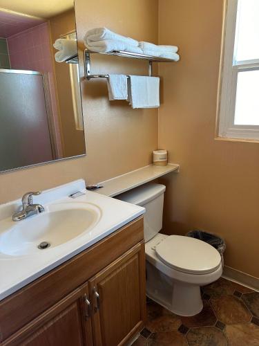 a bathroom with a sink and a toilet and a mirror at Fireside Inn in King City