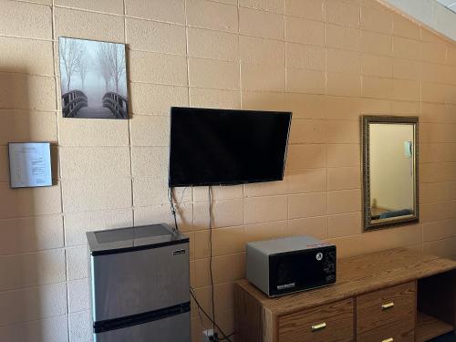a room with a microwave and a television on a wall at Fireside Inn in King City
