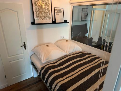 a bed in a room with a mirror at URBAN Studio Apartment mit Designerbad Sehr zentrale Lage 5 Minuten zu Fuß in die Innenstadt in Oldenburg