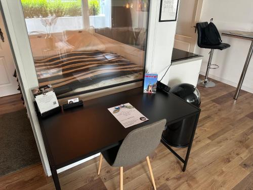 a black desk with a chair in a room at URBAN Studio Apartment mit Designerbad Sehr zentrale Lage 5 Minuten zu Fuß in die Innenstadt in Oldenburg