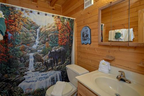a bathroom with a waterfall shower curtain and a sink at Wet Bear Paws #146 in Sevierville