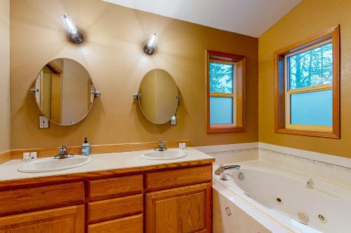a bathroom with two sinks and a tub and mirror at Fir Tree Getaway in Rhododendron