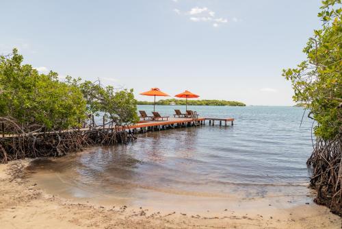 a beach with chairs and umbrellas in the water at Hotel Playa Scondida Barú in Baru