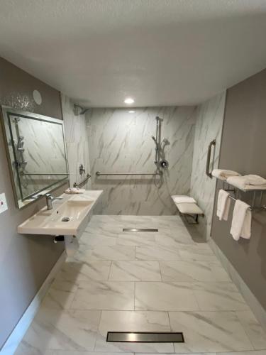 a white bathroom with a sink and a mirror at Motel 6-Costa Mesa, CA in Costa Mesa