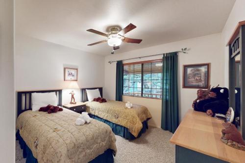 a bedroom with two beds and a ceiling fan at Lakeside Livin' in Pinetop-Lakeside