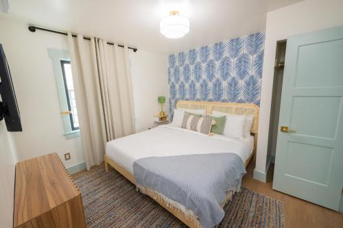 a bedroom with a bed and a television and a door at The Boardwalk Hotel in San Diego