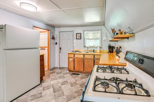 a kitchen with a stove and a white refrigerator at 5 Mi to Cave Run Lake Wellington Cabin with Deck! in Wellington