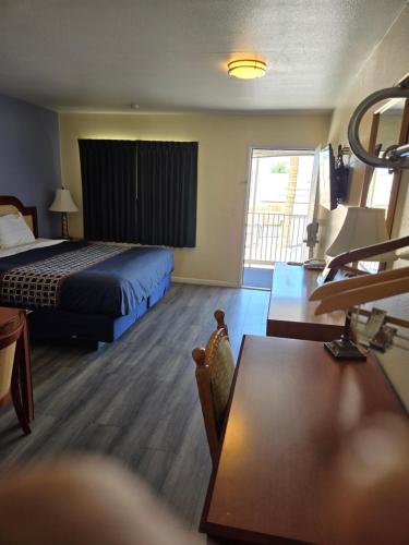 a hotel room with a bed and a table at Rodeway Inn & Suites Blythe I-10 in Blythe