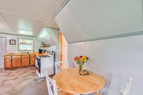 a kitchen with a table with a vase of flowers on it at 5 Mi to Cave Run Lake Wellington Cabin with Deck! in Wellington