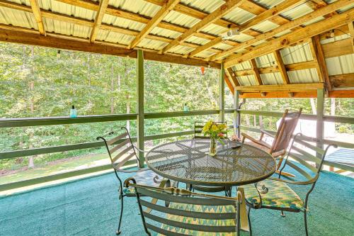 a table and chairs on the porch of a cabin at 5 Mi to Cave Run Lake Wellington Cabin with Deck! in Wellington