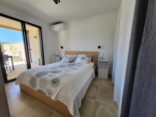 une chambre avec un lit et une grande fenêtre dans l'établissement Porticcio - Agosta Plage - T2 - Chez Cath et JC, à Albitreccia