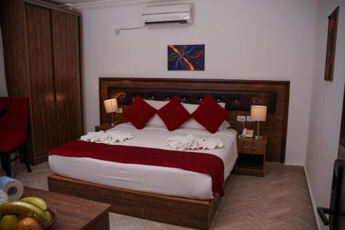 a bedroom with a large bed with red pillows at Petra Corner Hotel in Petra