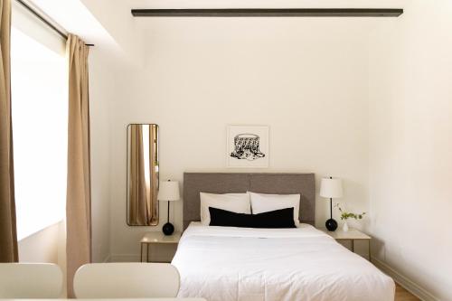 a bedroom with a white bed and a white chair at Maison Rasco by Luxury In Transit in Montréal