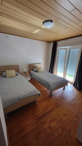 a bedroom with two beds and a wooden ceiling at Planinska kuća Rezo Rakitno in Posušje