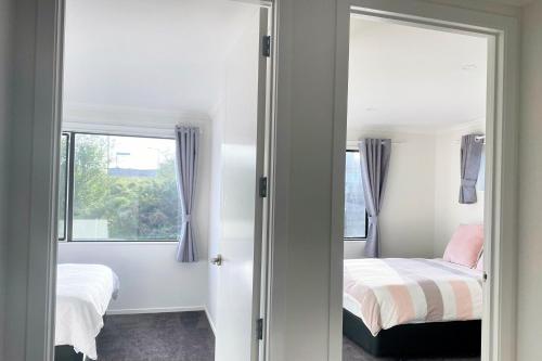 a bedroom with a bed and a mirror and a window at Wonderful River View - Sunset Deck Retreat in Hamilton