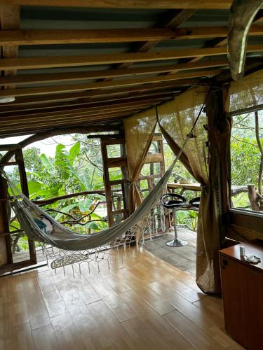 a hammock in the middle of a room at "refugio entre montañas" lalomaecolodge in Dosquebradas