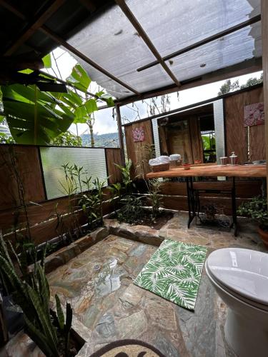 patio con tavolo, alcune piante e servizi igienici di "refugio entre montañas" lalomaecolodge a Dosquebradas