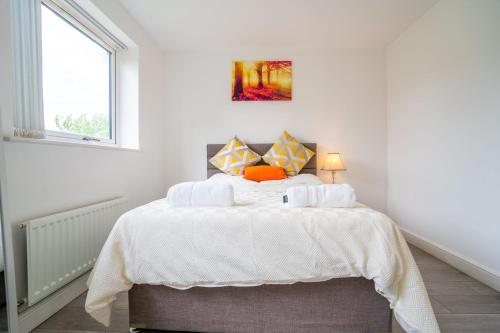 a white bedroom with a bed with white sheets at Mulberry Garden in Coventry