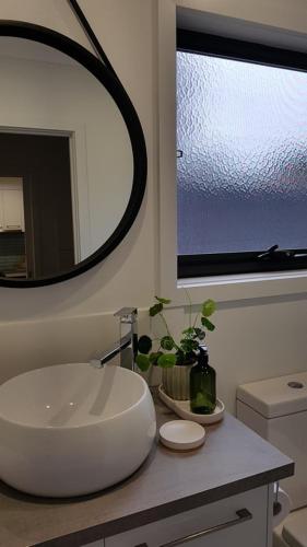 a bathroom with a large white sink and a mirror at At Home Apartments in Sale