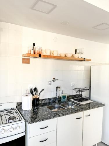 a white kitchen with a sink and a stove at Cuatro Estaciones in General Pico