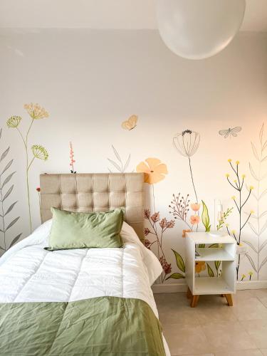 a bedroom with a bed with flowers on the wall at Cuatro Estaciones in General Pico