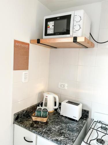a kitchen counter with a toaster and a microwave at Cuatro Estaciones in General Pico