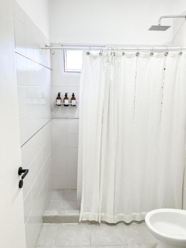 a bathroom with a shower curtain and a toilet at Cuatro Estaciones in General Pico