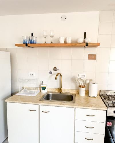 a kitchen with white cabinets and a sink at Cuatro Estaciones in General Pico
