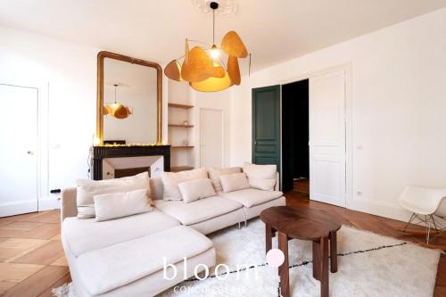 Le Lafayette Coeur de ville 6 personnes في نانسي: غرفة معيشة مع أريكة بيضاء ومرآة