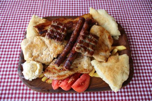 a plate of food with bacon and other foods on a table at Domacinstvo na kraju svijeta in Šipovo