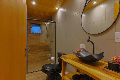 a bathroom with a sink and a mirror on a counter at Requinte dos Pinhais Chalé in Santo Antônio do Pinhal