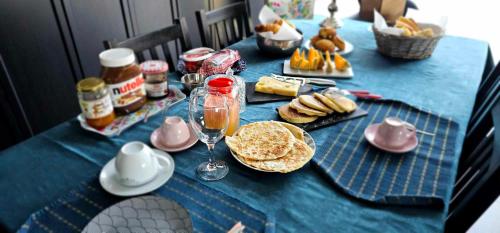 une table bleue avec un chiffon de table bleu avec de la nourriture et des boissons dans l'établissement Comme à la maison, à Monnaie